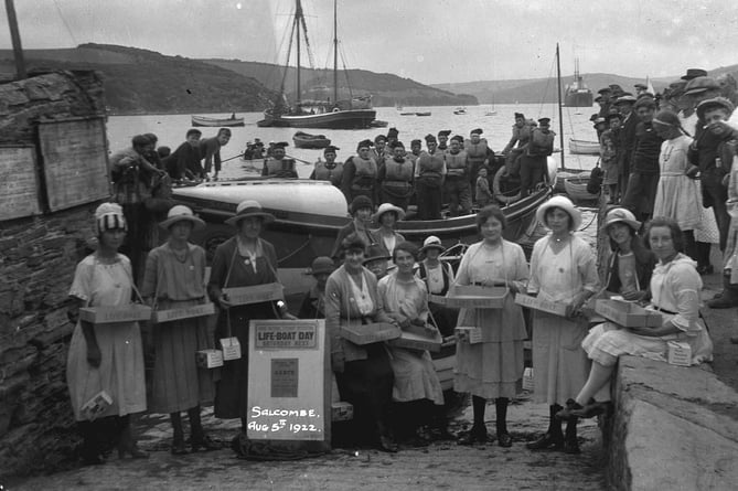 Lifeboat Day, Salcombe. August 5th 1922 (from poster). Ladies' committee grouped on slipway, lifeboat moored behind them with crew on board, other onlookers on walls.